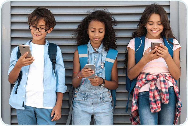 three middle school students using cell phones